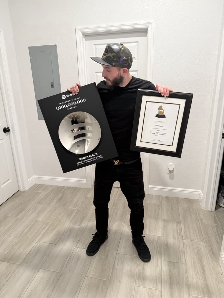 Killshot holding a Spotify billion-stream plaque and a recording certificate