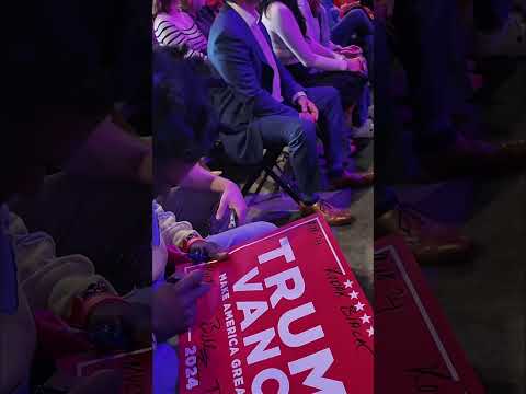Kodak signs a Donald trump poster for a fan